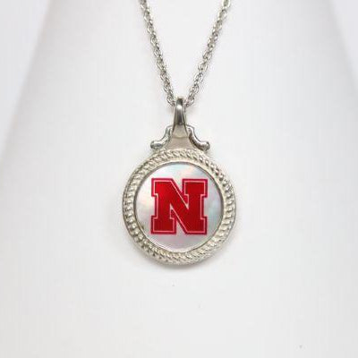 Perfect for any season! Each Mother of Pearl is one-of-a-kind. Features: Sterling silver Mother of pearl with Husker Red enamel inlay Lobster clasp Officially licensed product Pendant box included