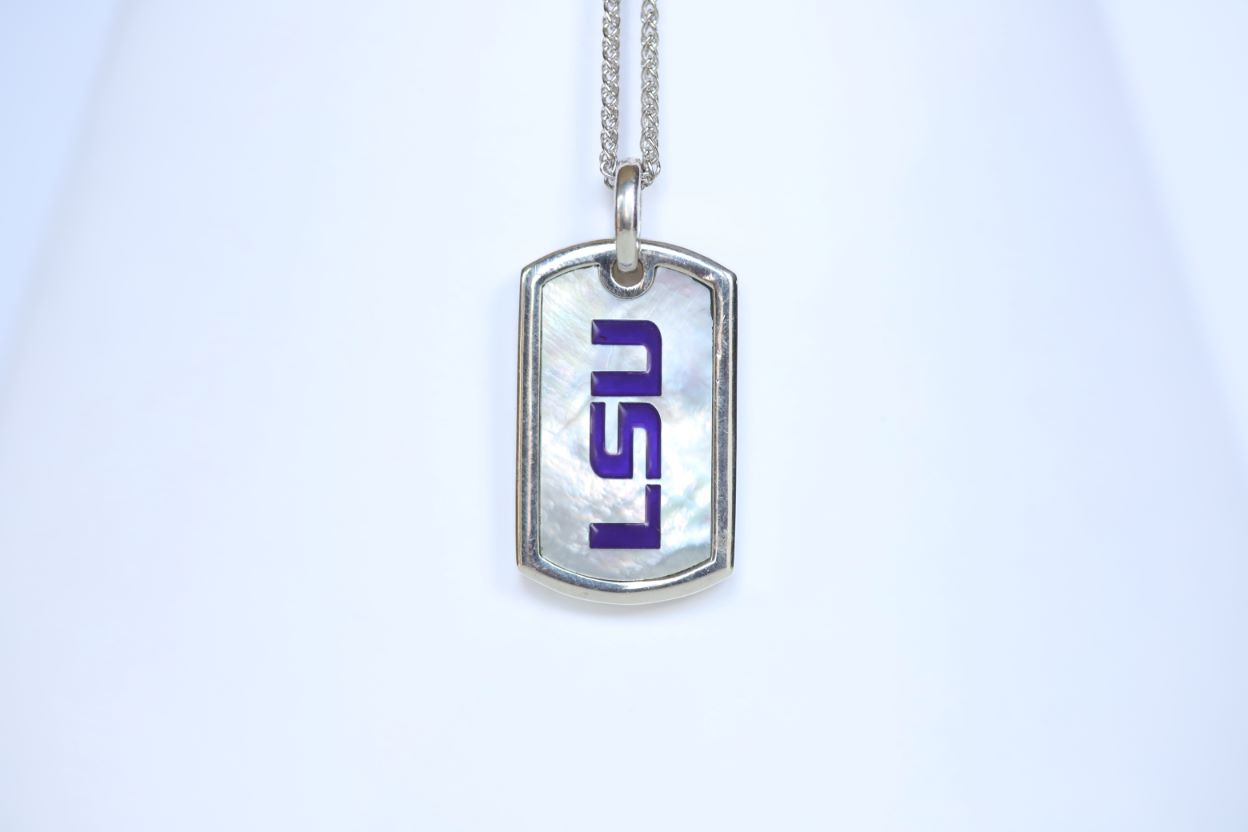 This piece is perfect for men or women! Each Mother of Pearl is one-of-a-kind. Features: Sterling silver Mother of pearl with purple enamel inlay Lobster clasp Pendant: 29x17mm LSU Loisianna State University