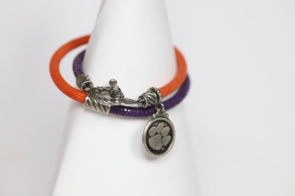 Finish off your Clemson game day look with our purple and orange stingray leather charm bracelet.   Features:  Sterling silver Toggle clasp Stingray leather  Double sided charm Officially licensed product
